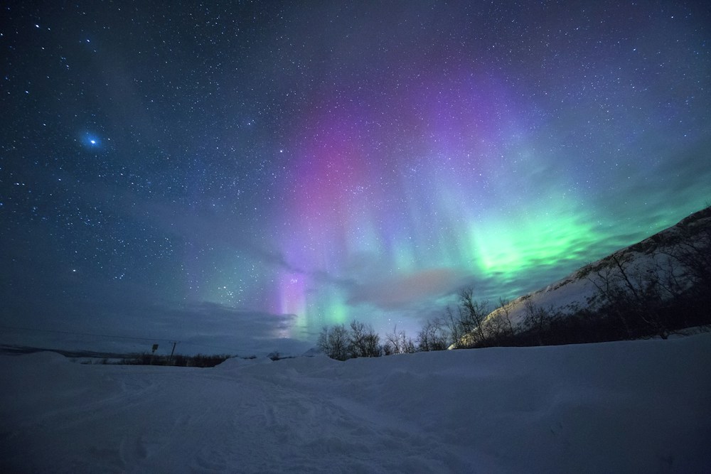 Aurora above a snowy mountain landscape