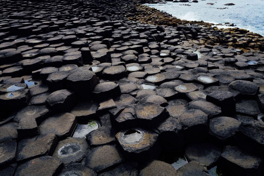 Interlocking hexagonal basalt columns of the Giant's Causeway beside the sea