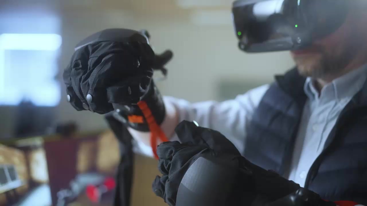 A headset user demonstrating HaptX gloves in manufacturer footage.